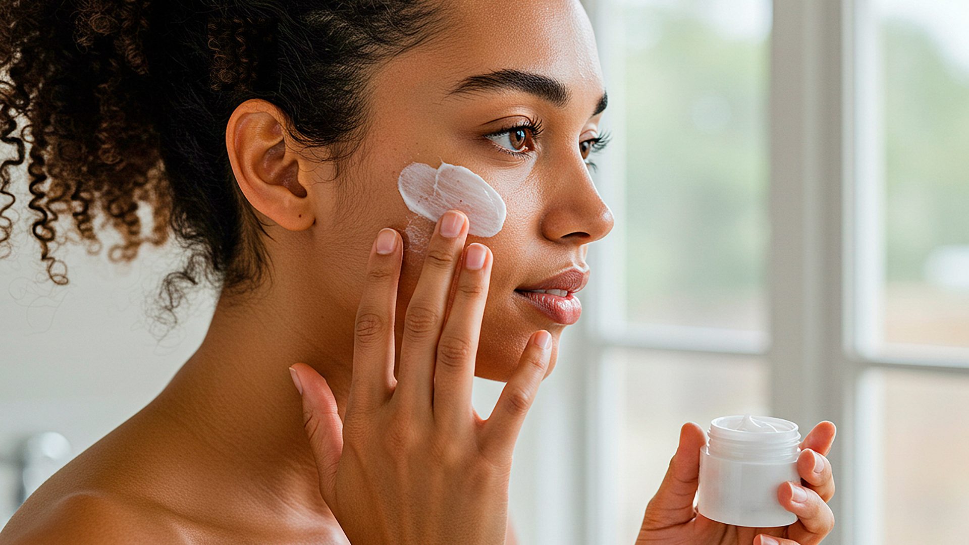 Woman with oily skin applying oil-free tinted moisturizer for matte finish